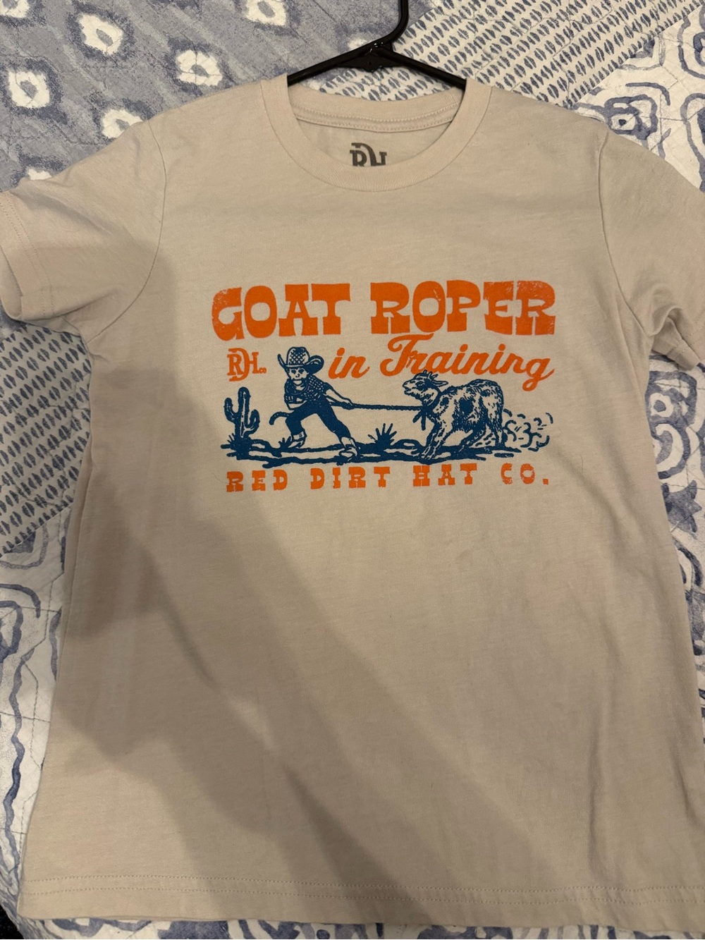 "Goat Roper in Training" Kids Tee - Tan with Orange & Blue Print